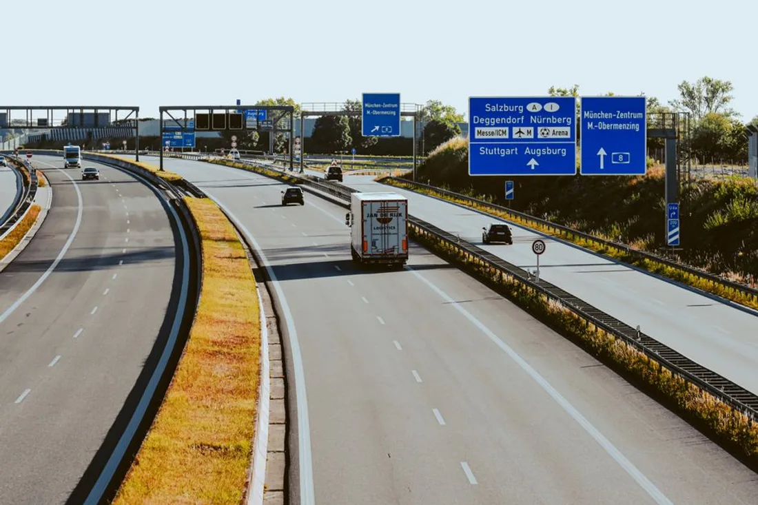 Deutsche Autobahn mit Wegweisern und einem Lastwagen